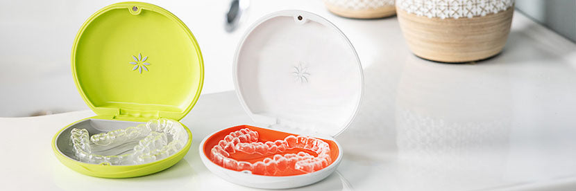 Open lime green and white Invisalign aligner cases collection