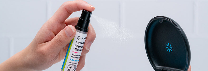 Invisalign cleaning spray being sprayed at aligners in case collection