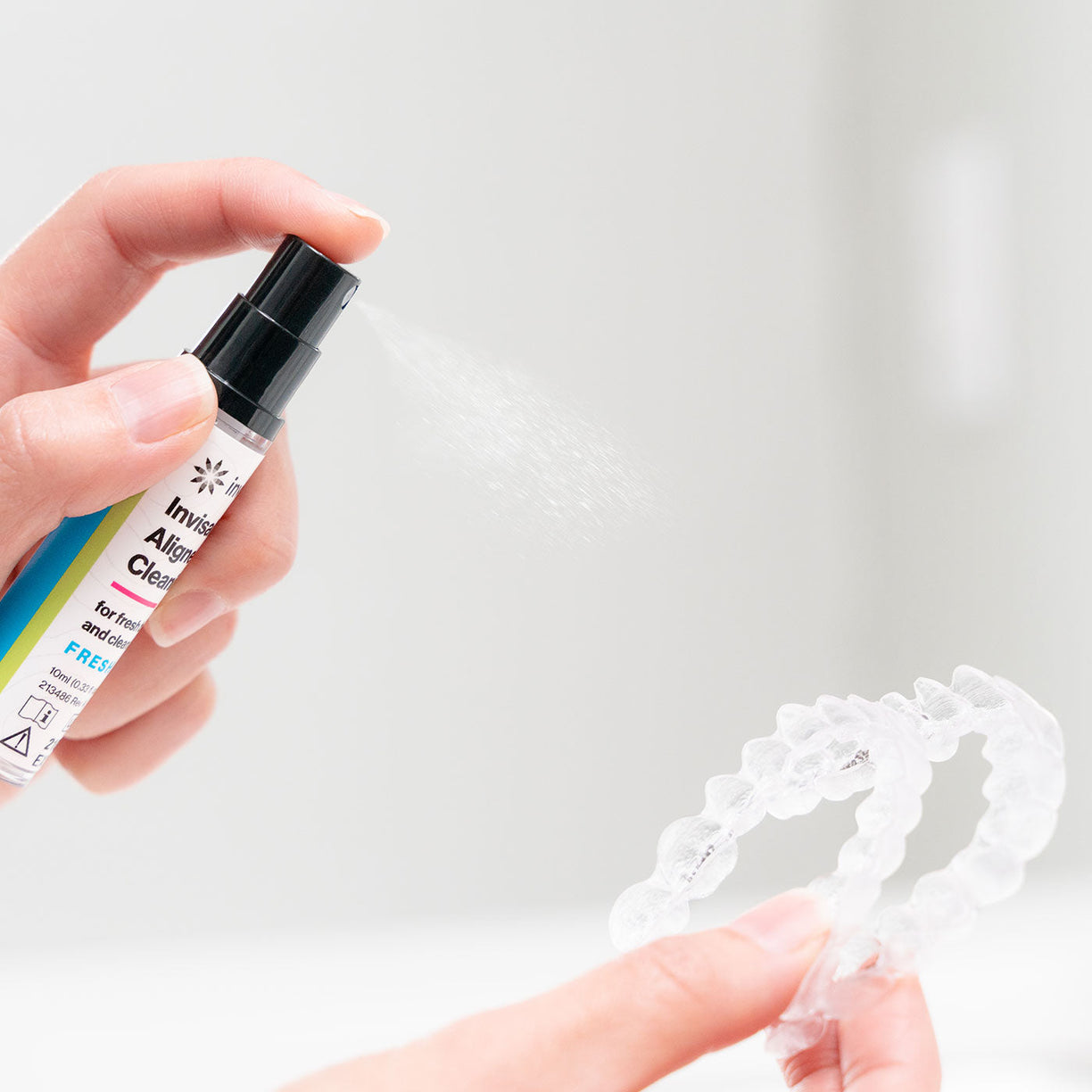 Video of person using Invisalign aligner cleaning spray