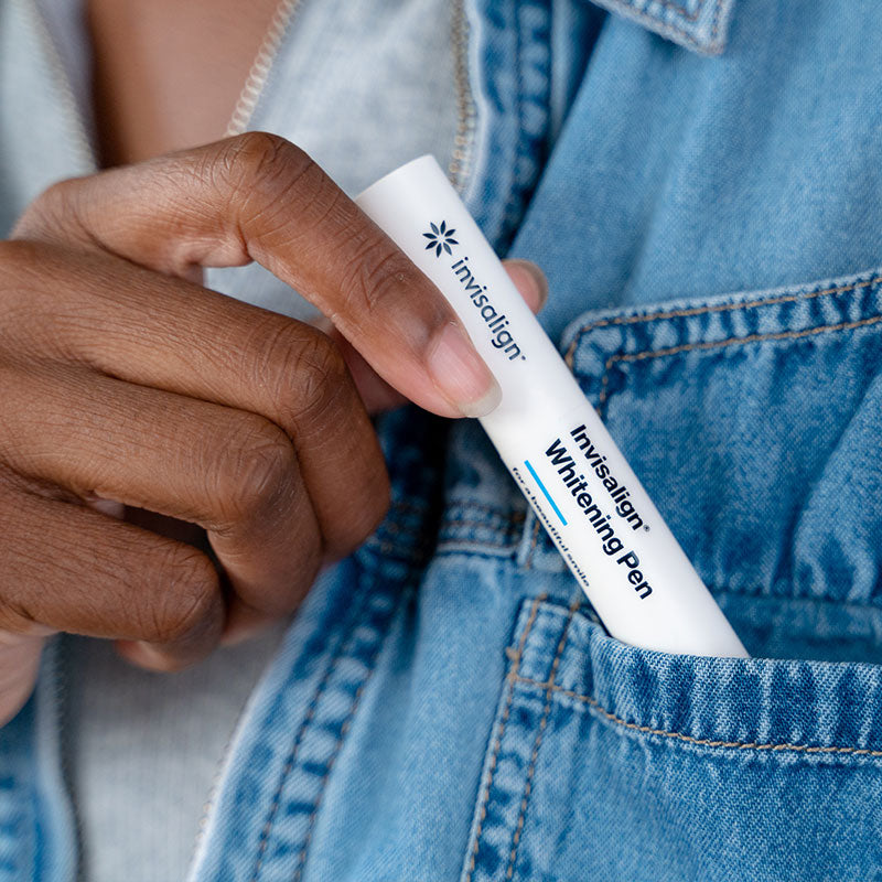 Person putting Invisalign whitening pen into pocket