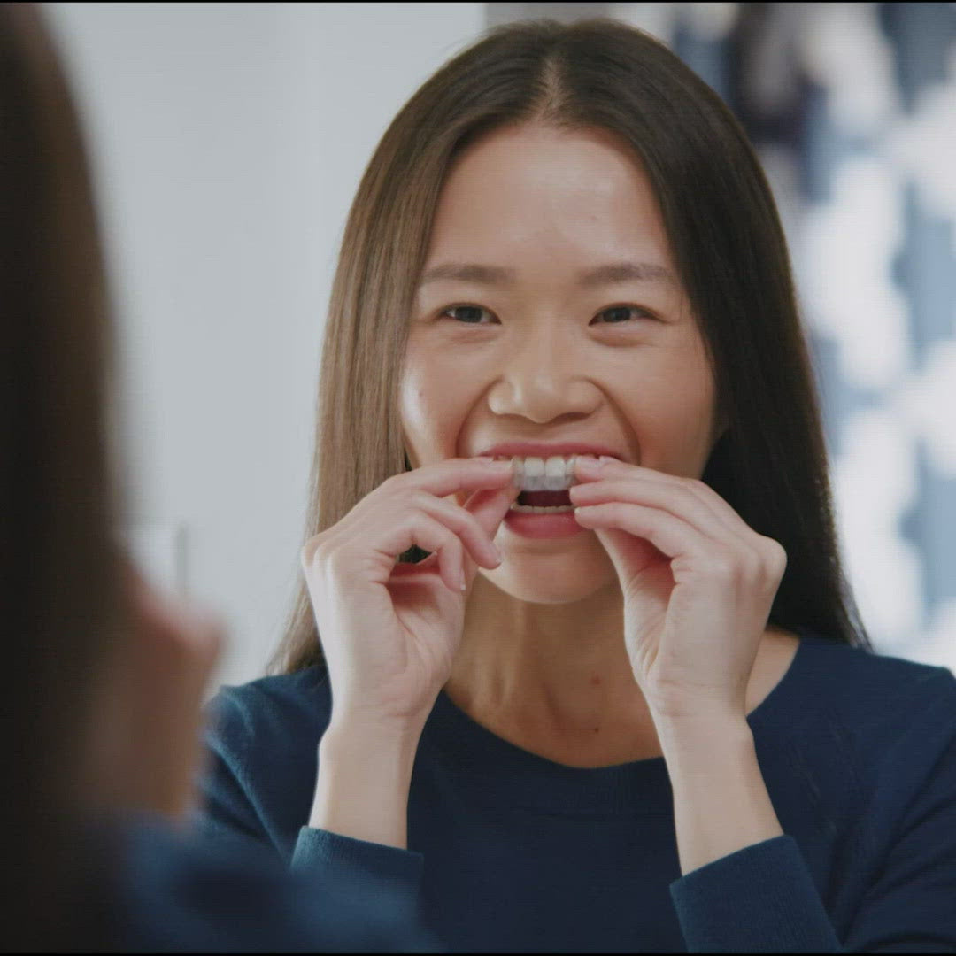 Person spraying aligners with Invisalign cleaning spray