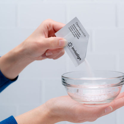Hand pouring Invisalign cleaning crystals pack